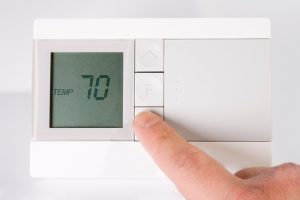 Stock image of hand adjusting thermostat